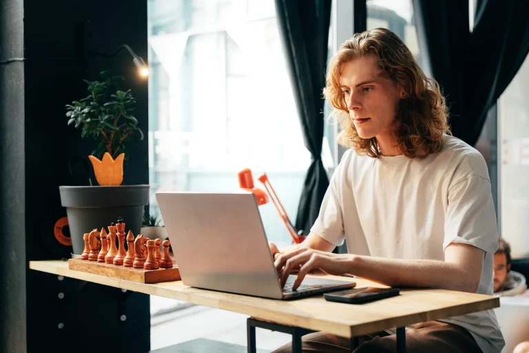 Mann arbeitet in einem Café am Laptop